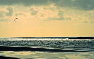 a person is flying a kite on the beach at Vila hangloose vista da lagoa in Acaraú