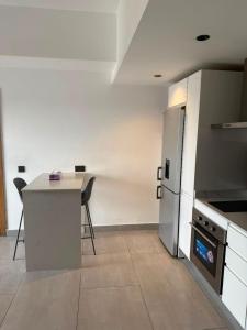 a kitchen with a counter and a table and a refrigerator at QUATTRO-Sky Suites in Accra +25 photos
