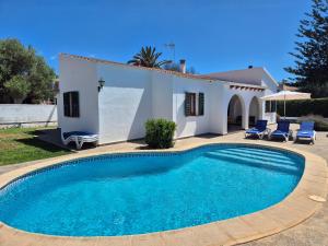 a villa with a swimming pool in front of a house at Villa familiar con piscina privada en Calan Blanes in Cala en Blanes
