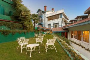 a group of chairs sitting on the grass in front of a building at Clarkes hotel, A grand heritage hotel since 1898 in Shimla