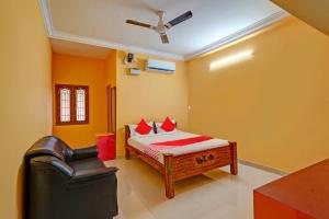 a bedroom with a bed and a chair in it at Hotel O by OYO DHANAS BEST AMBIENCE in Kuilapayam +24 photos