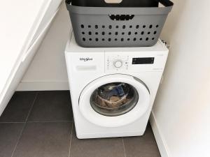 a washing machine with a basket on top of it at Wonenmeteenknipoog Groningerweg 23D in Peize
