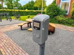 a parking meter in front of a picnic table at Wonenmeteenknipoog Groningerweg 23D in Peize