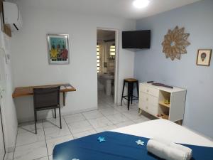 a bedroom with a bed and a desk and a table at Kazajany in Terre-de-Haut
