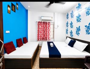two beds in a room with blue and white walls at Trip Kashi Guest House in Varanasi +19 photos