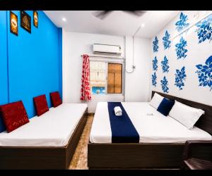 two beds in a room with blue and white walls at Trip Kashi Guest House in Varanasi