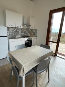 a kitchen with a table and chairs and a kitchen with white cabinets at Aria Case Vacanze - Frumento in Favignana +25 photos