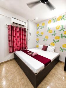 a bedroom with a bed with flowers on the wall at Trip Kashi Guest House in Varanasi