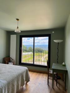 a bedroom with a bed and a window with a view at La Grange Guesthouse in Beausemblant