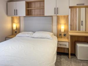 a bedroom with a bed with white sheets and cabinets at Drover's Den - Uk50090 in Durham