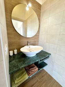 a bathroom with a sink and a mirror at Aria Case Vacanze - Frumento in Favignana