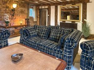 a blue couch in a living room with a table at Ye Olde Stone House in Sutton Coldfield