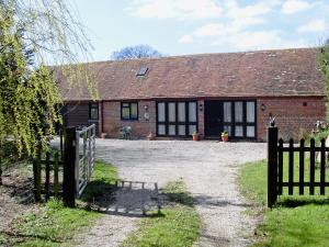 a brick house with a gate in front of it at High House Holiday Cottages 1 in Hooe