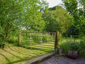 a gate in a field with trees and grass at High House Holiday Cottages 1 in Hooe +4 photos