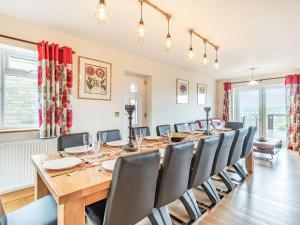 a large dining room with a long table and chairs at Paradise in Cinderford