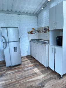a kitchen with a white refrigerator and a sink at Cabaña entre Cafetales in Manizales