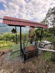 a gazebo with a picnic table and a grill at Cabaña entre Cafetales in Manizales