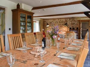 a long wooden table with glasses and a bottle of wine at The Granary in Oxborough