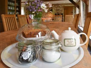 a table with a plate of cake and jars on it at The Granary in Oxborough