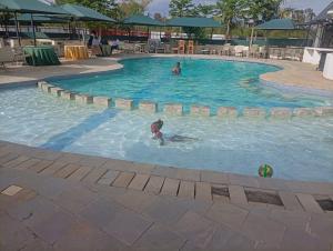 two people in a swimming pool with a ball in the water at Grand Forty Garden Ltd in Kisumu +1 photo