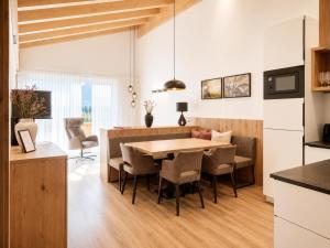 a kitchen and dining room with a table and chairs at Alpenstolz Damüls Haus 1 - Stilvoll urlauben in den Bergen in Damuls