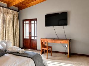a bedroom with a desk and a television on the wall at Myrtle Leaf Apartments in Springs