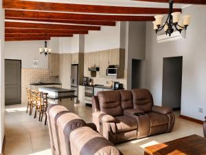 a living room with leather furniture and a kitchen at Myrtle Leaf Apartments in Springs
