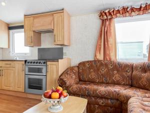 a living room with a couch and a bowl of fruit on a table at Oakmere - Uk51989 in Oakmere