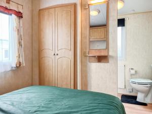 a small bedroom with a bed and a toilet at Oakmere - Uk51989 in Oakmere