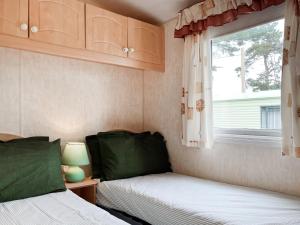 a bedroom with two beds and a window at Oakmere - Uk51989 in Oakmere +8 photos