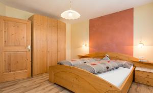 a bedroom with a large bed with wooden walls at Lüch de Tor in San Martino in Badia