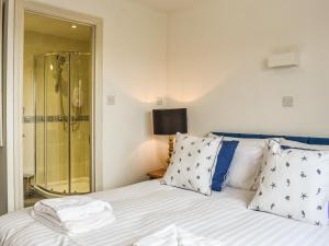 a bedroom with a shower and a bed with pillows at Evergreen House in Runswick +26 photos