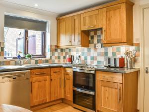 a kitchen with wooden cabinets and a stove top oven at Evergreen House in Runswick