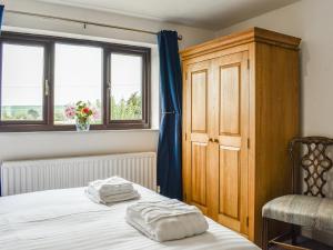 a bedroom with a bed and a cabinet and windows at Evergreen House in Runswick