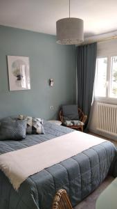 a bedroom with a large bed and a window at la Villa des Fleurs in La Bourboule