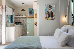 a small kitchen with a bed and a green refrigerator at בצל הדקל in Bet Leẖem HaGelilit