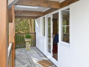 a porch with white walls and windows and a porch at River Lodge in Polperro