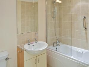 a bathroom with a sink and a shower and a tub at River Lodge in Polperro
