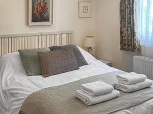 a white bed with towels on top of it at River Lodge in Polperro