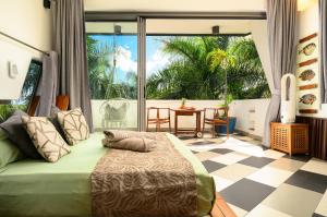 a bedroom with a bed and a large window at Villa Mauritius - Designer Private Studios in Pointe aux Sable