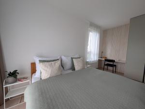 a white bedroom with a bed and a couch at Apartment VIEW 27 in Olomouc