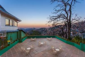 
a patio area with a patio table and chairs at Clarkes hotel, A grand heritage hotel since 1898 in Shimla
