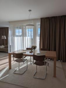 a dining table and chairs in a living room at Apartment VIEW 27 in Olomouc