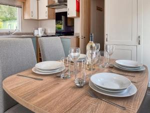 a wooden table with plates and wine glasses on it at Whispering Pines Spa - Uk50087 in Durham