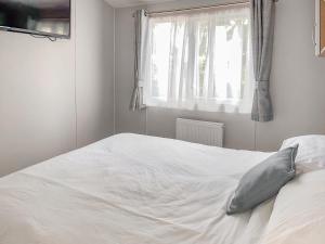 a white bed in a bedroom with a window at Whispering Pines Spa - Uk50087 in Durham +12 photos