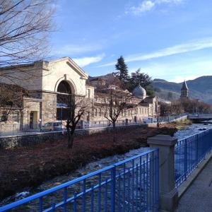 a building with a blue fence in front of it at la Villa des Fleurs in La Bourboule