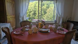 a red table with food on it with a window at la Villa des Fleurs in La Bourboule