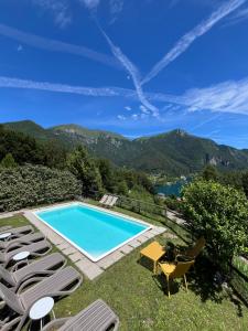 a pool with chairs and a view of the mountains at Casa Europa in Ledro