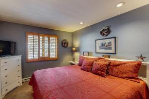 a bedroom with a large bed with a red blanket at Whispering Pines in Durango Mountain Resort +50 photos
