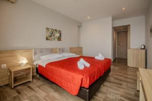 a bedroom with a bed with a red bedspread at Alyssium in Benitses